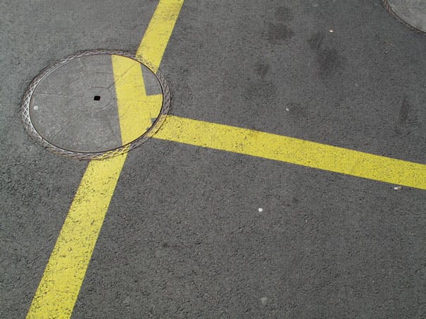 Misaligned road surface marking over a drainage hole